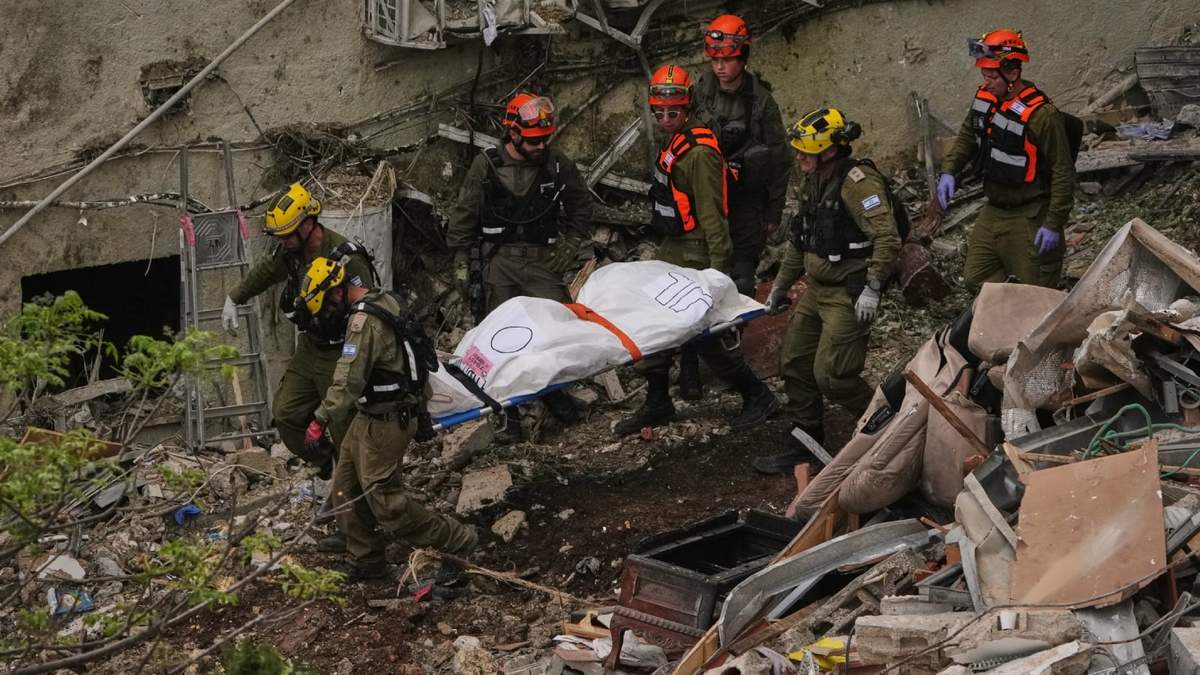 Personal de rescate y militares trasladan el cuerpo de una víctima de entre los escombros de un edificio residencial un día después de que fuera alcanzado por un misil iraní en Haifa, Israel, el lunes 6 de abril de 2026