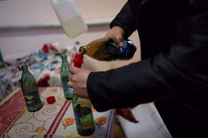 Imagen de archivo de un hombre fabricando un coctel molotov