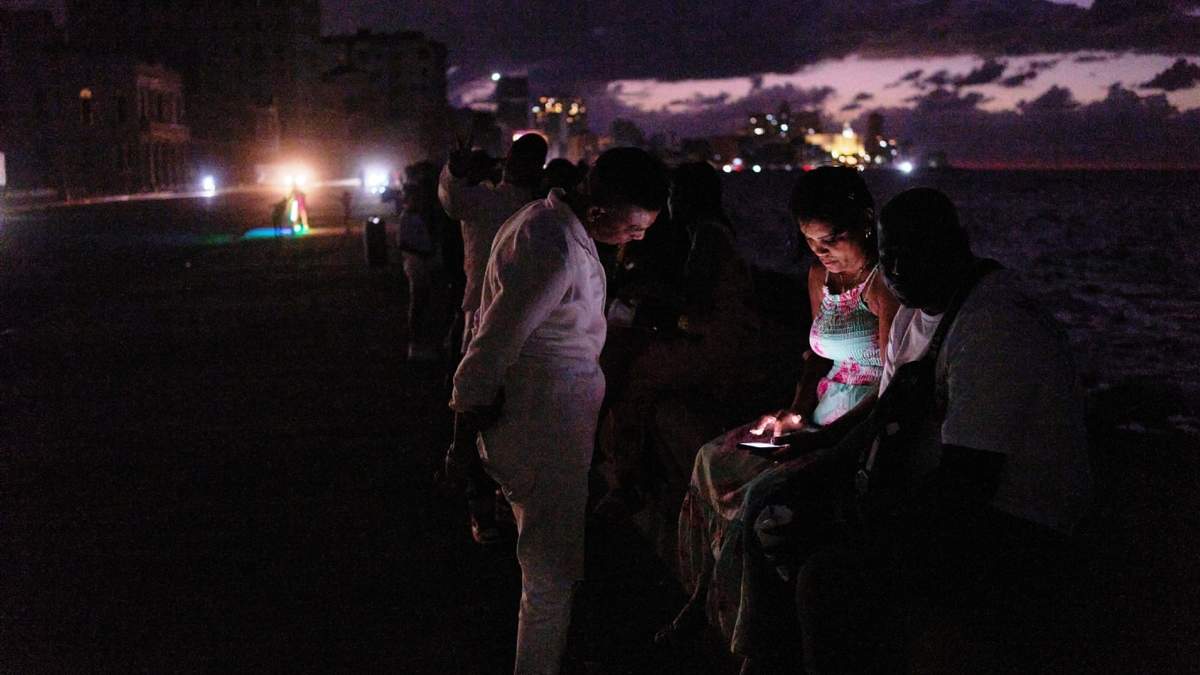 Gente pasa la noche en la oscuridad en el Malecón durante un apagón en La Habana, Cuba, el sábado 21 de marzo de 2026