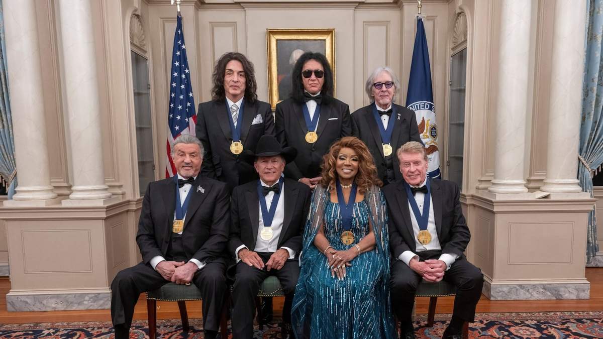 En primera fila de izquierda a derecha: Sylvester Stallone, George Strait, Gloria Gaynor y Michael Crawford; en la fila de atrás de izquierda a derecha: los miembros del grupo de rock Kiss Paul Stanley, Gene Simmons y Peter Criss