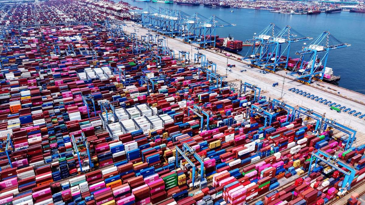 Grúas cargan y descargan contenedores de buques en una terminal de contenedores en Qingdao, en la provincia de Shandong, China