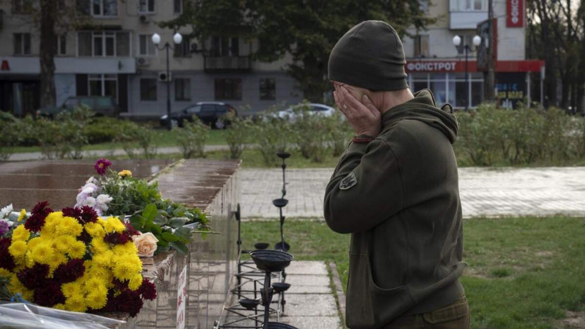 Una mujer perteneciente a las fuerzas armadas ucranianas llora tras colocar flores para recordar a quienes han muerto en la guerra con Rusia