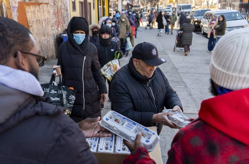 Abou Sow entrega cartones de huevo a personas que esperan formadas para recibirlos de manera gratuita de parte de FarmerJawn Agriculture, 21 de marzo de 2025, Harlem, Nueva York