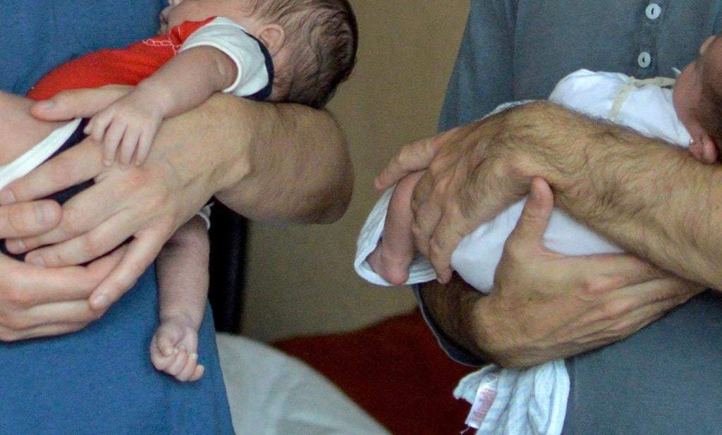 Bebés cargados por sus padres