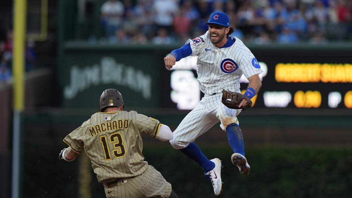 Dansby Swanson, de los Cachorros de Chicago, salta sobre Manny Machado de los Padres de San Diego en el tercer juego de la serie de comodines de la Liga Nacional