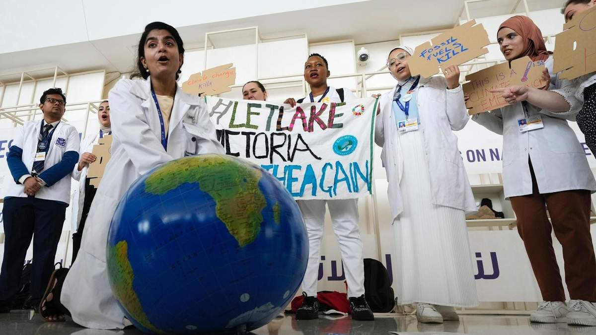 Una mujer simula reanimar a la Tierra en una manifestación en la conferencia climática COP28