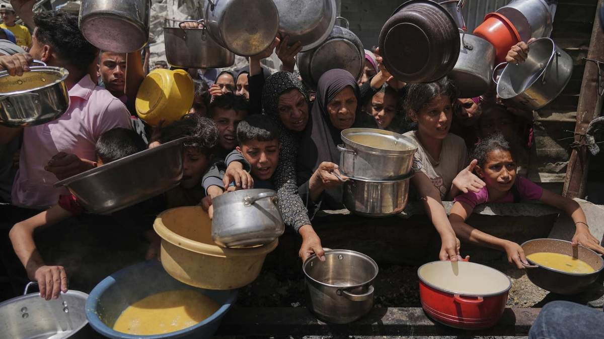 Palestinos tratan de obtener alimentos donados en una cocina comunitaria en Jabalia, en el norte de la Franja de Gaza