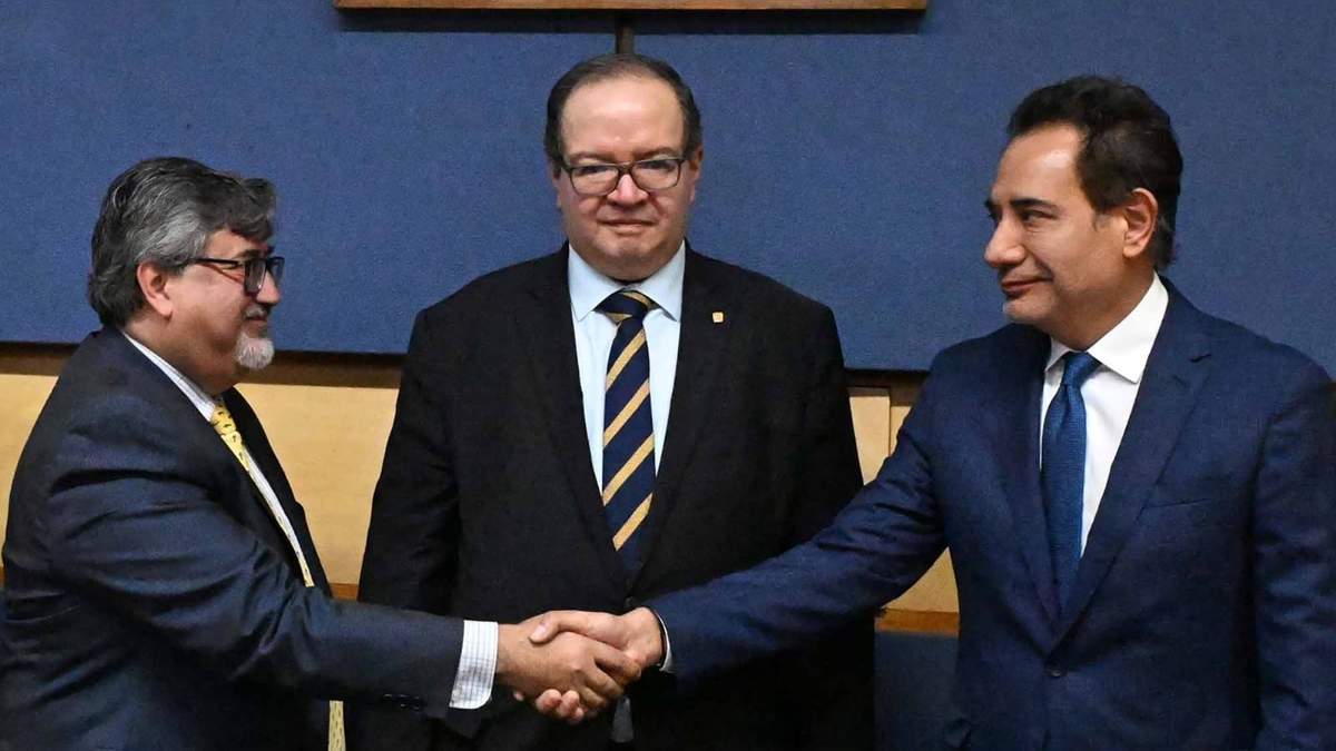 Exsecretario de Prevención y Apoyo a la Movilidad y Seguridad Universitaria (SPAMSU) de la UNAM, Raúl Arcenio Aguilar Tamayo, estrecha la mano del recién nombrado titular de esa misma Secretaría, mientras el rector, Leonardo Lomelí Vanegas, observa