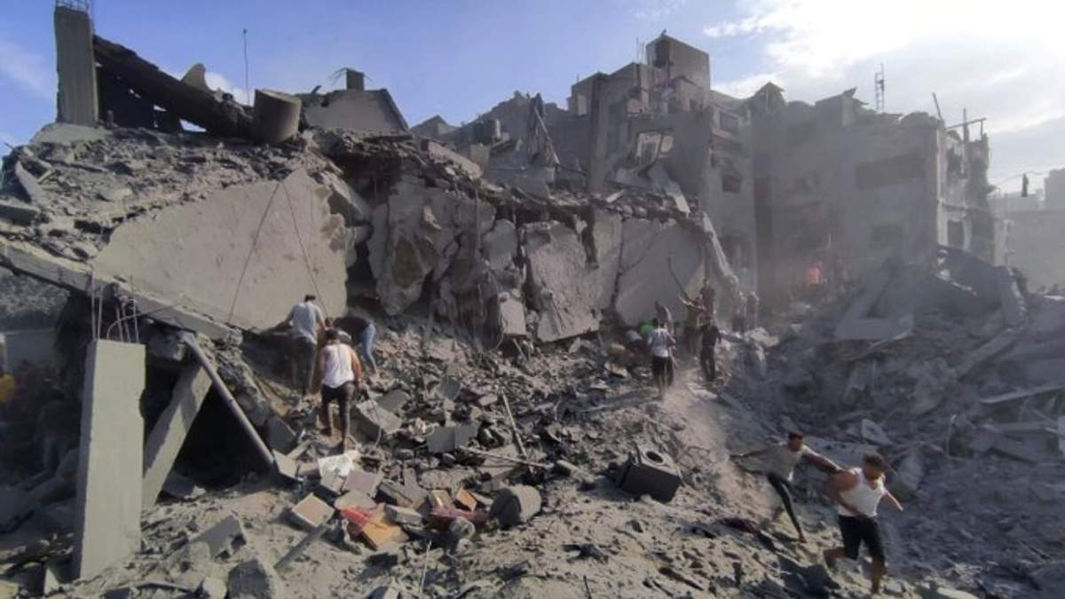 Palestinos heridos buscan salir de los escombros de un edificio atacado por israelíes