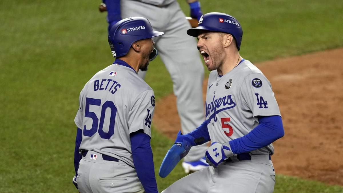 Mookie Betts y Freddie Freeman de los Dodgers de Los Ángeles celebran tras anotar carreras