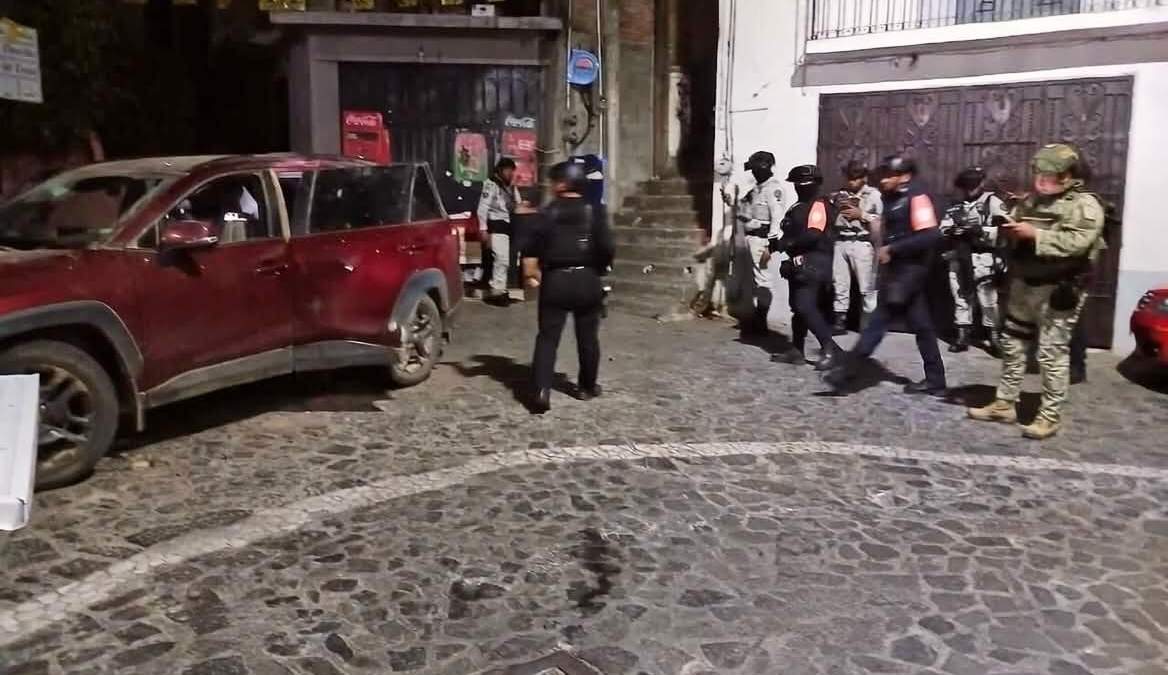 Fuerzas de seguridad estatales y federales resguardan una camioneta de presuntos delincuentes tras una balacera en Taxco