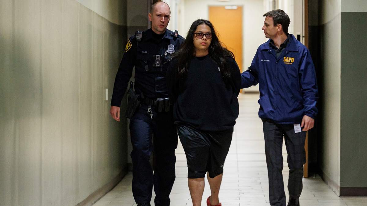 Christopher Preciado, centro, de 19 años, es escoltado por policías de San Antonio