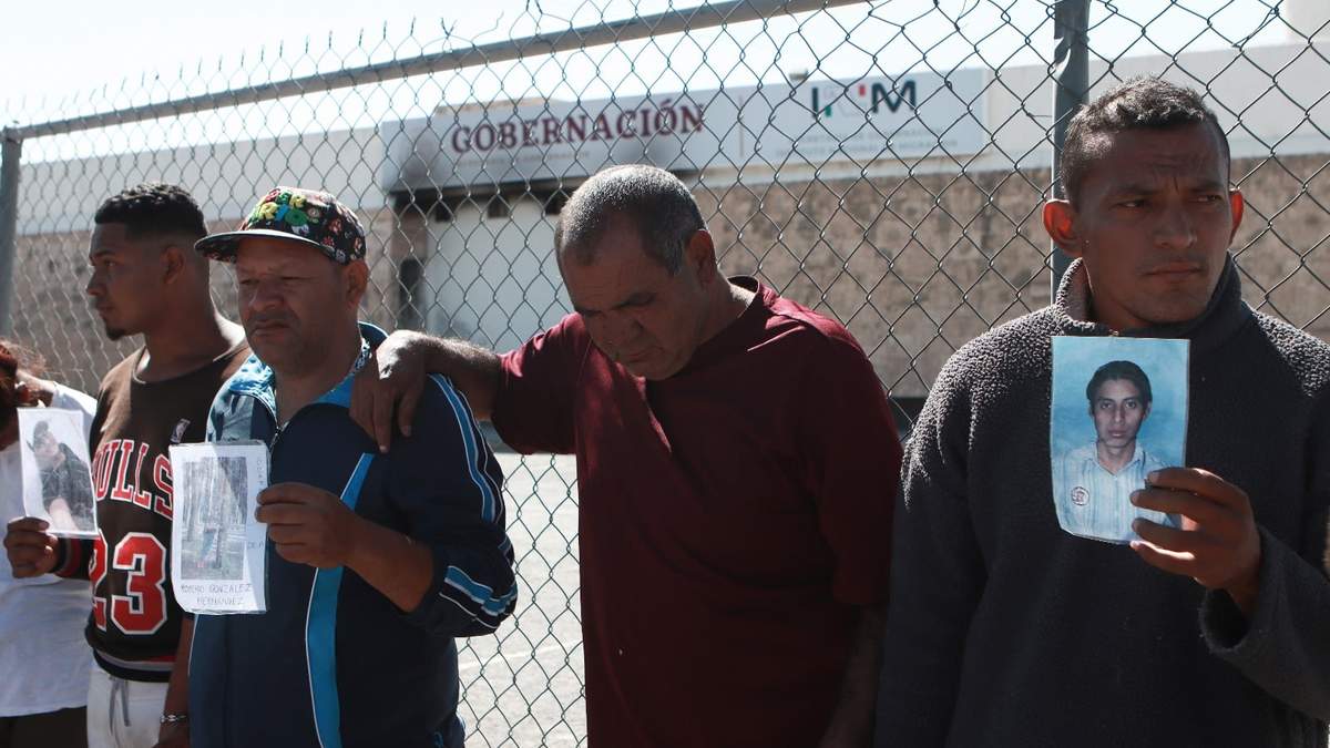 Migrantes de Venezuela muestran fotos de quienes murieron en un incendio en el centro de detención
