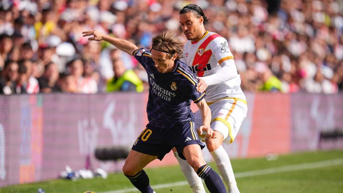 Luka Modric pugna por el balón con Raúl de Tomás del Rayo Vallecano