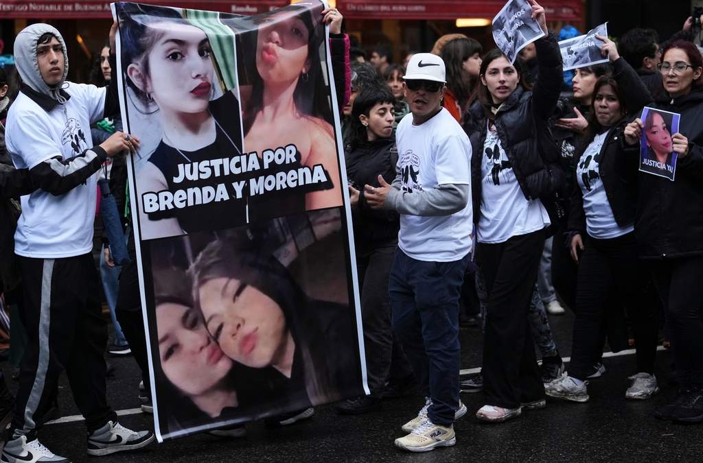 Varias personas sostienen una foto de Brenda del Castillo, Morena Verdi y Lara Gutiérrez, mientras protestan por su tortura y asesinato, que las autoridades atribuyen a bandas de narcotraficantes, durante una manifestación convocada por grupos feministas en Buenos Aires, Argentina, el sábado 27 de septiembre de 2025