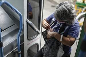 Una mujer busca dinero para pagar su pasaje
