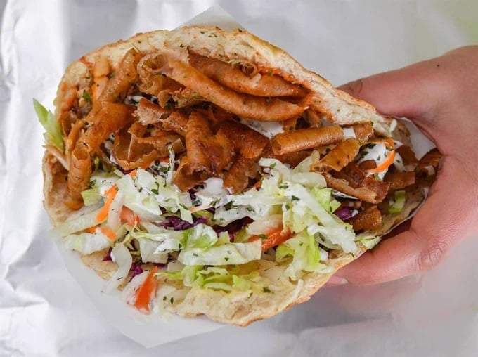 Una persona con un kebab de pollo