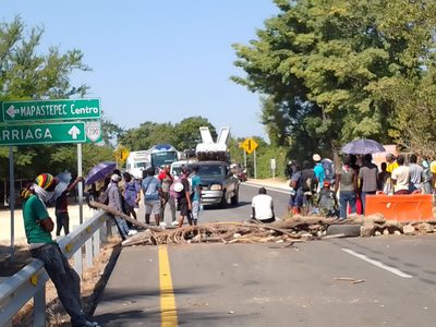 Migrantes realizan bloqueo para pedir “aventón”; transportistas  los desalojan con palos y piedras