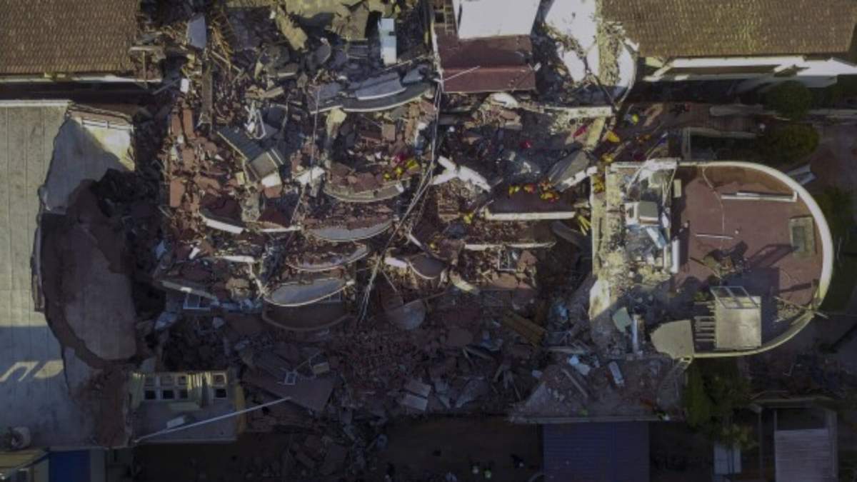 Bomberos y rescatistas buscan sobrevivientes entre los escombros del hotel Dubrovnik parcialmente derrumbado, en Villa Gesell, Argentina