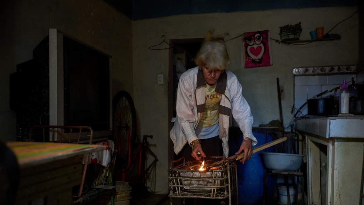 Minorkys Hoyos Ruiz enciende carbón para cocinar la cena el martes 3 de febrero de 2026, durante un apagón programado con el fin de racionar la energía en Santa Cruz del Norte