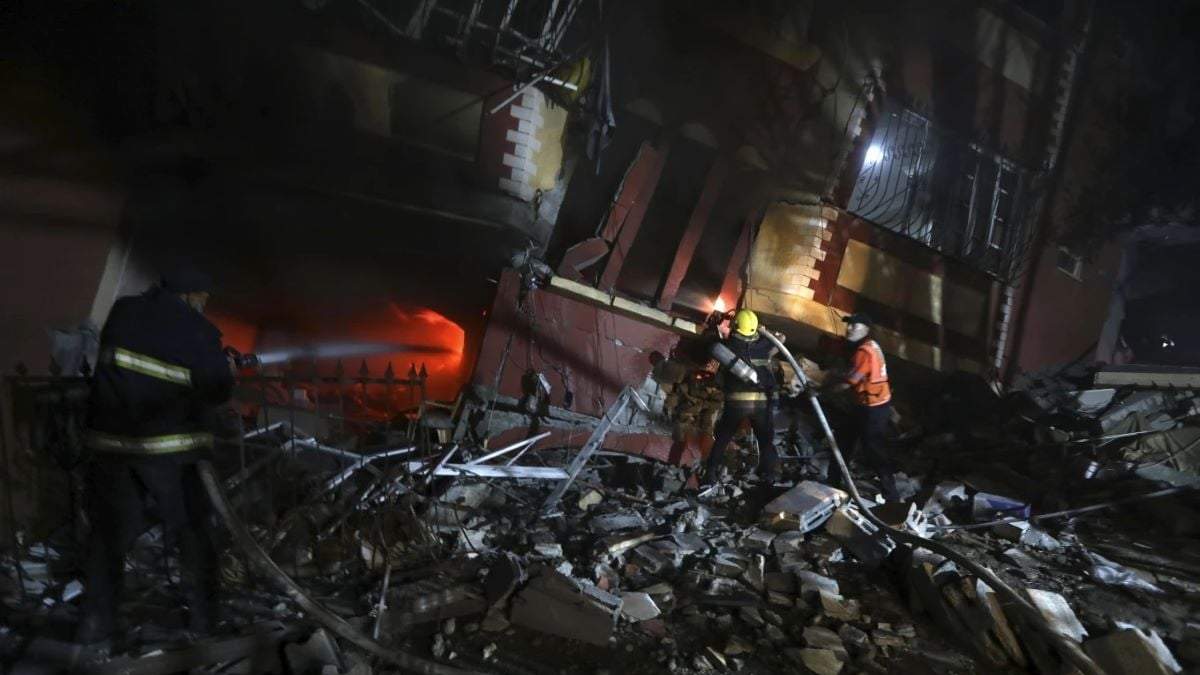 Palestinos tratan de apagar el fuego en una casa luego de los bombardeos israelíes en la Franja de Gaza el 8 de octubre de 2023