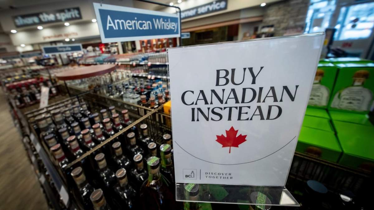 Un letrero frente a la sección de whisky estadounidense en una licorería de Columbia Británica, Canadá, recomienda comprar productos nacionales, en Vancouver, el 2 de febrero de 2025