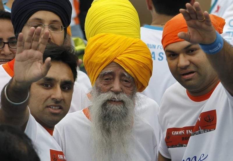 Fauja Singh, corredora de maratón centenaria (centro), sonríe tras finalizar una carrera de 10 kilómetros, celebrada en el Maratón de Hong Kong, el 24 de febrero de 2013.