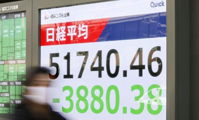 Gente ante una pantalla que muestra el índice bursátil japonés Nikkei en una firma de inversión el lunes 9 de marzo en Tokio