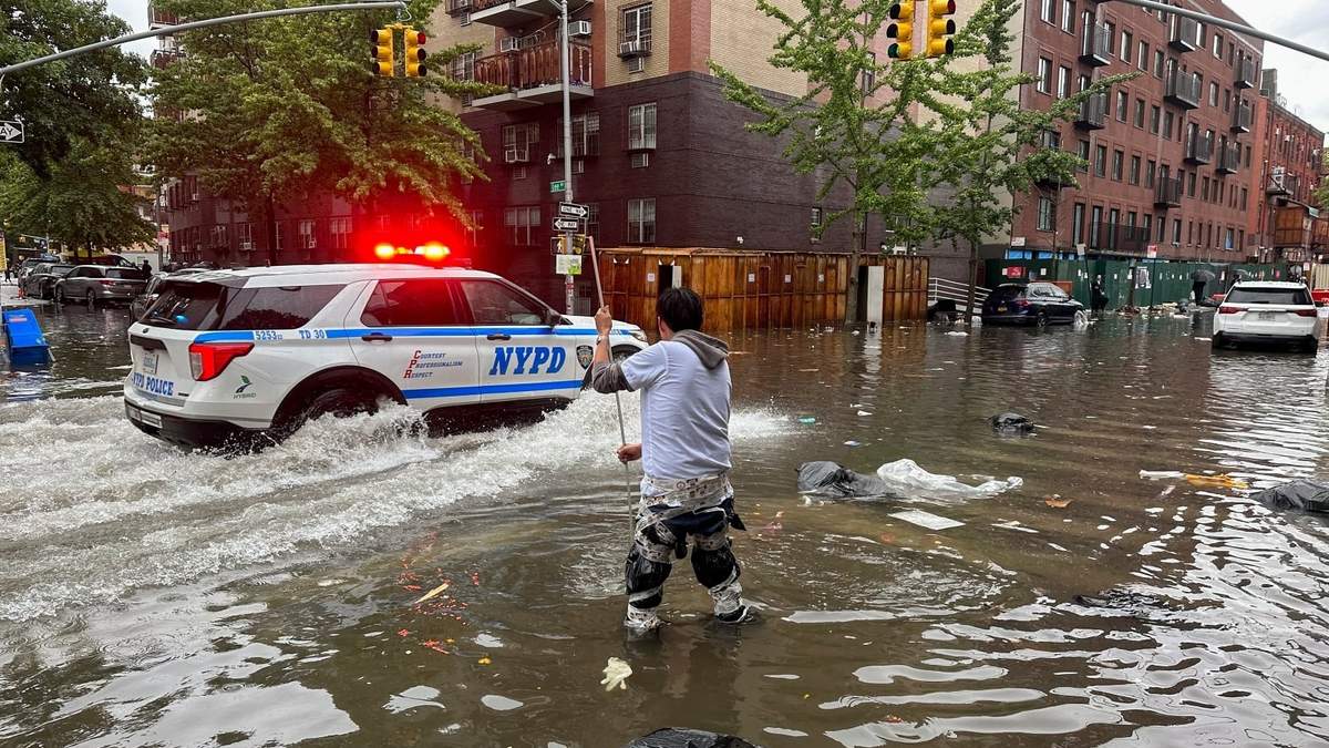 Un hombre intenta destapar una coladera en el distrito de Brooklyn de Nueva York