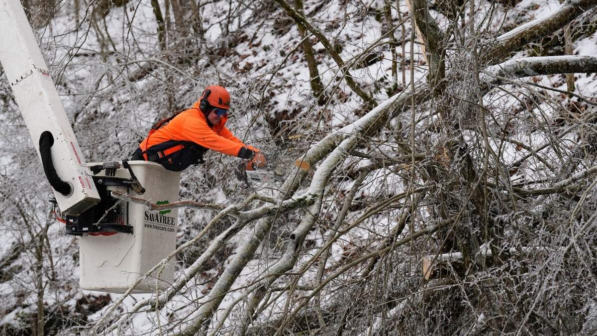 Austin Bradbury utiliza una motosierra para cortar una rama de un árbol sobre una carretera, el 30 de enero de 2026, en Nashville, Tennessee