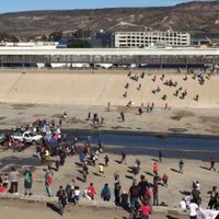 Migrantes rompen cerco de PF en frontera con EU; Guardia Nacional lanza gases para persuadirlos (video)