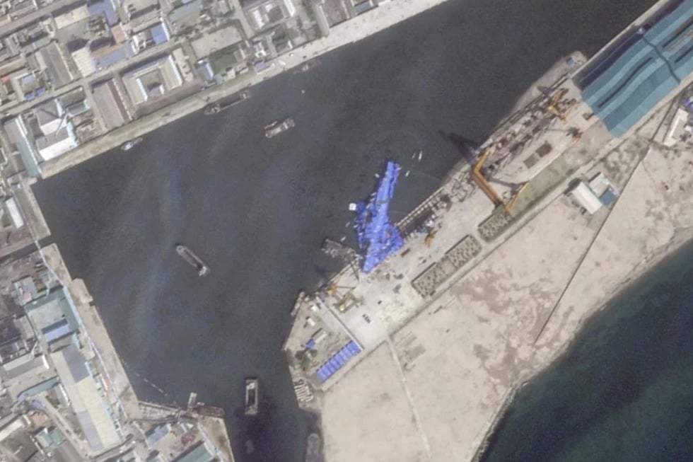 Esta imagen satelital de Planet Labs PBC muestra una lona azul que cubre un destructor norcoreano después de que sufriera un lanzamiento fallido mientras se hacía a la mar en Chongjin, Corea del Norte, el viernes 23 de mayo de 2025.