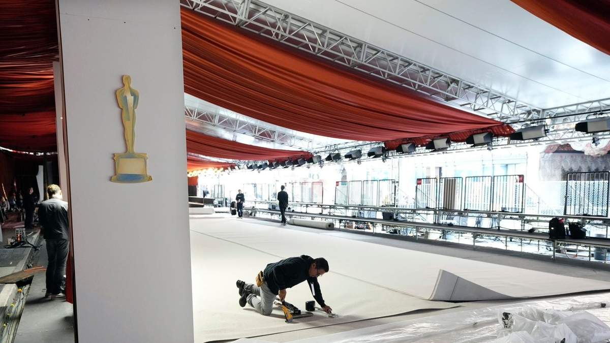 Un trabajador engrapa una alfombra durante los preparativos para la 95a edición de los Premios Oscar