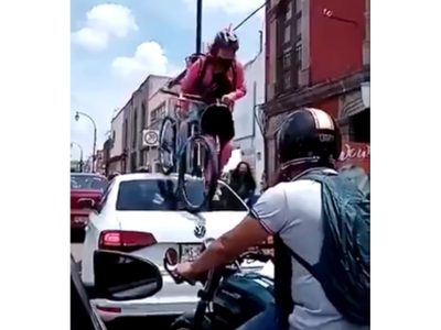 Mujer ciclista pasa por encima de un auto que invadió ciclovía en Querétaro