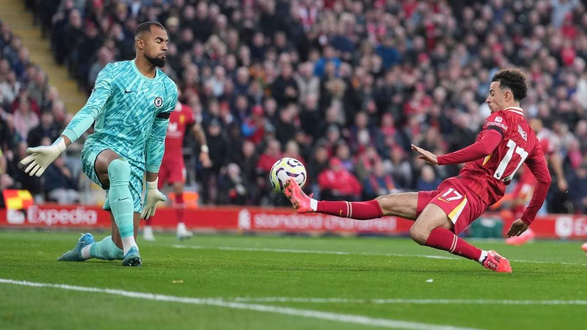 Curtis Jones (derecha) anota el segundo gol de Liverpool ante el arquero Robert Sánchez en la victoria 2-1 ante Chelsea en la Liga Premier, el domingo 20 de octubre de 2024, en Liverpool