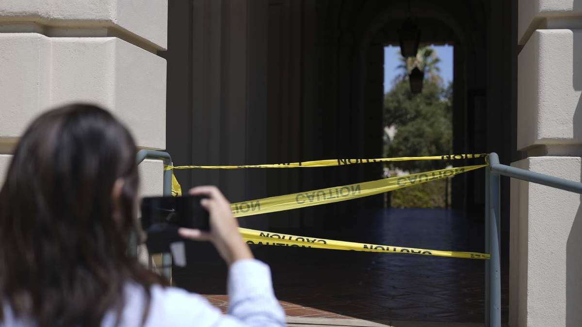 Una mujer toma una fotografía de una parte acordonada por la policía del Ayuntamiento de Pasadena, California, tras un sismo de magnitud 4,4.
