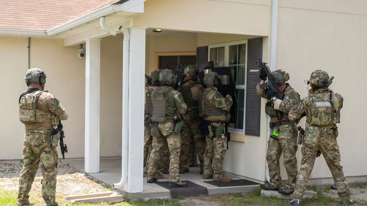 Miembros de un equipo de respuesta especial del Servicio de Control de Inmigración y Aduanas (ICE) muestran cómo entran a una vivienda para dar con una persona buscada, en el centro de formación federal en Brunswick, Georgia