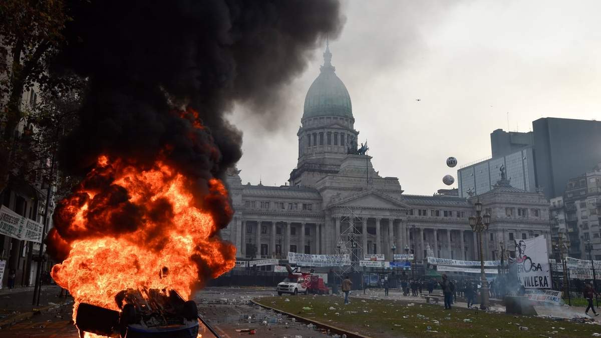 Un automóvil arde durante enfrentamientos entre la policía y manifestantes antigubernamentales frente al Congreso de Argentina
