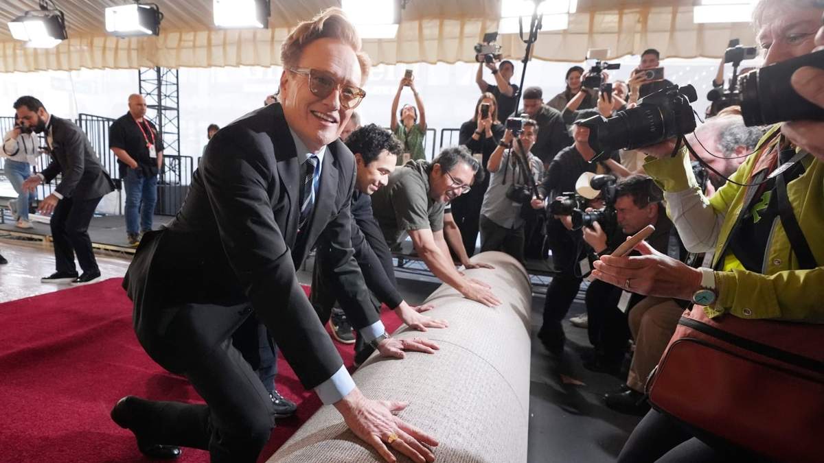 Conan O'Brien, presentador de la 97ª edición de los Premios de la Academia del domingo, ayuda a desenrollar la alfombra roja para el espectáculo en el Dolby Theatre el miércoles 26 de febrero de 2025 en Los Ángeles