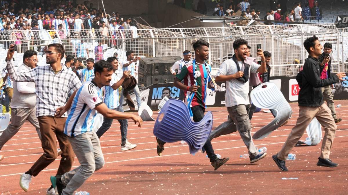 Aficionados arrancan las sillas en su carrera hacia el césped tras no haber podido ver al astro argentino Lionel Messi en el estadio Salt Lake, en Calcuta