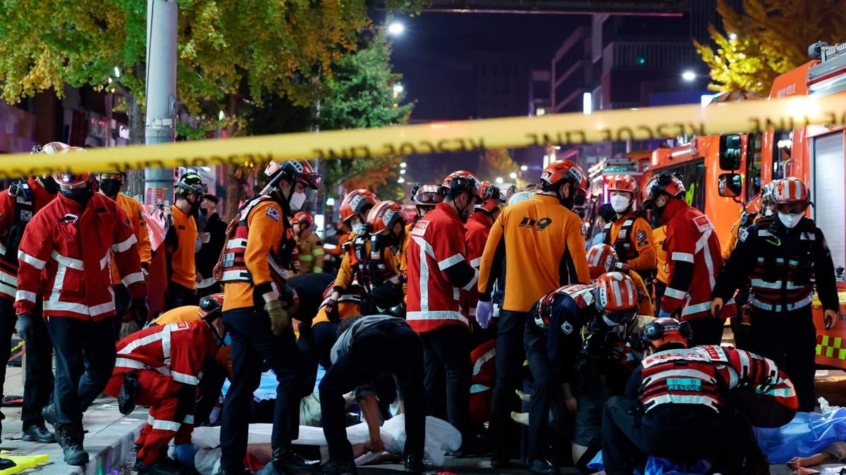 Socorristas y bomberos trabajan en la escena de una estampida fatal en Seul
