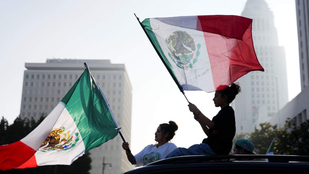 Manifestantes ondean banderas durante una protesta para pedir una reforma a la inmigración, el 2 de febrero de 2025, en Los Ángeles