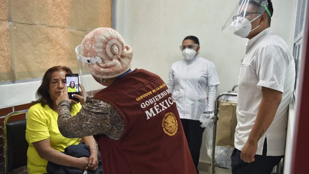 Una servidora de la Nación toma foto de una persona vacunada