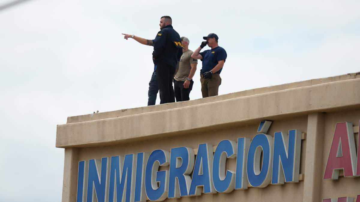 Agentes del orden público revisan el techo de un edificio de apartamentos cerca del sitio donde ocurrió un tiroteo contra una oficina del Servicio de Inmigración y Control de Aduanas en Dallas, el miércoles 24 de septiembre de 2025