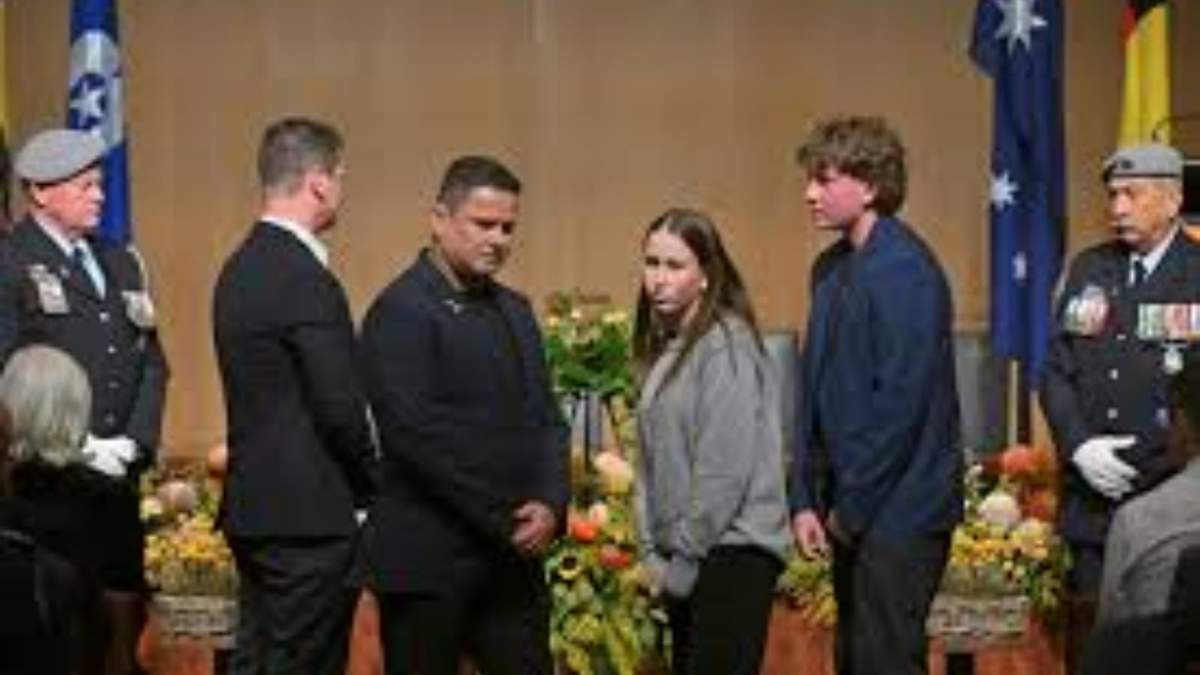 Familiares de los pasajeros fallecidos en el derribo del vuelo 17 de Malaysia Airlines sobre Ucrania colocan una ofrenda floral en una reunión con autoridades en la sede del Parlamento en Canberra,