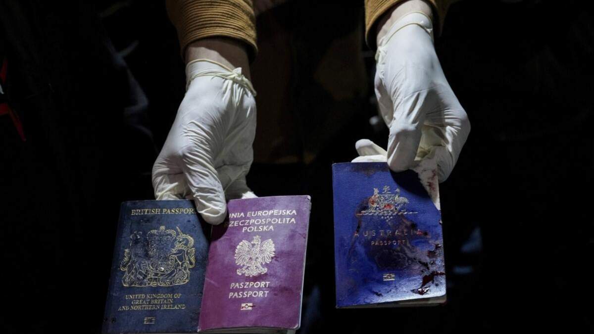 Un hombre sostiene pasaportes manchados de sangre de Reino Unido, Polonia y Austraila tras un ataque israelí, en Deir al-Balah, Franja de Gaza