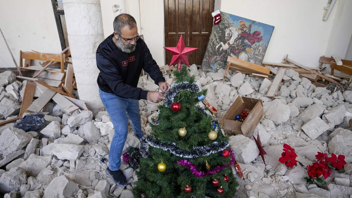 Georges Elia decora un árbol de Navidad dentro de la iglesia de San Jorge, que fue destruida por un ataque aéreo israelí, en la ciudad de Dardghaya, en el sur del Líbano