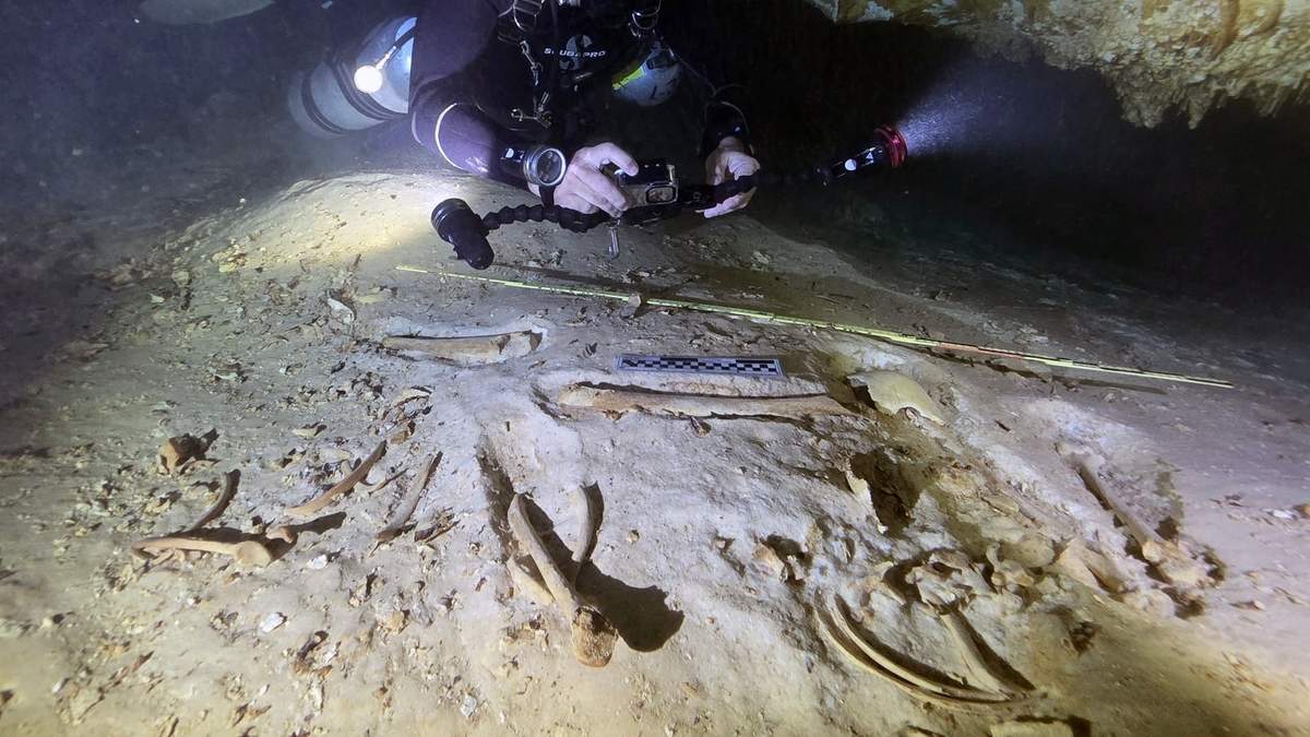 El arqueólogo submarino Octavio del Río toma fotos de los restos de un esqueleto humano prehistórico descubierto dentro del sistema de cuevas inundadas cerca de Tulum