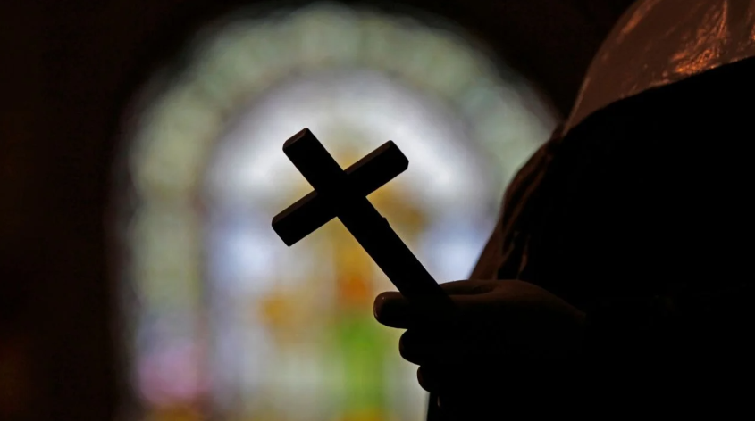 Una persona sostiene una cruz cristiana (imagen ilustrativa)