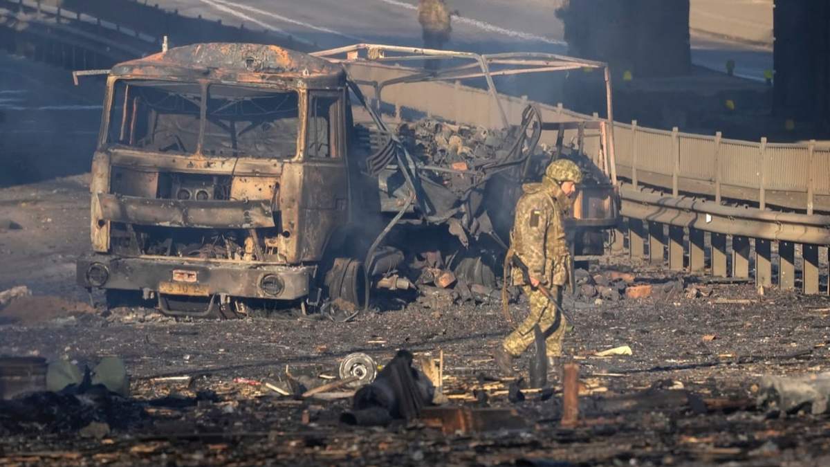 Un soldado ucraniano se desplaza entre los restos de un camión militar incendiado en una calle en Kiev, Ucrania